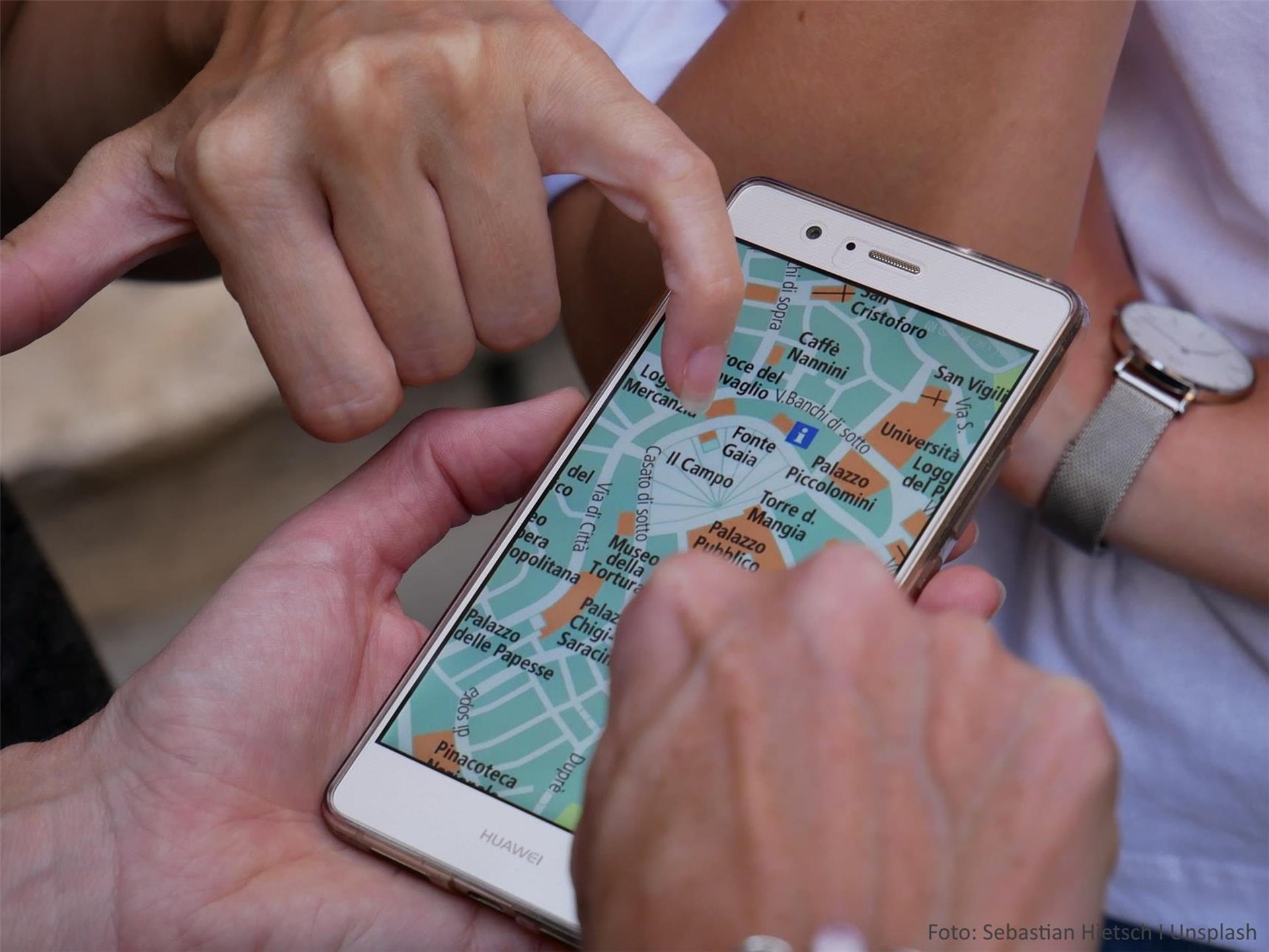 Personen blicken auf Karte am Smartphone
