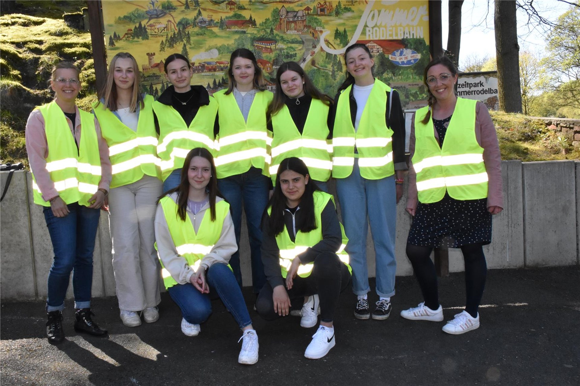 Eine Gruppe junger Menschen trägt Warnwesten